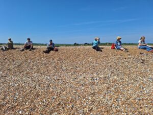 Birders relaxing on a shingle beach.